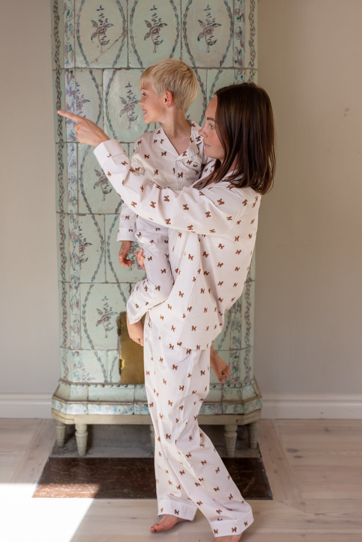 Adult holding a child in matching brown and white Doodle pajamas