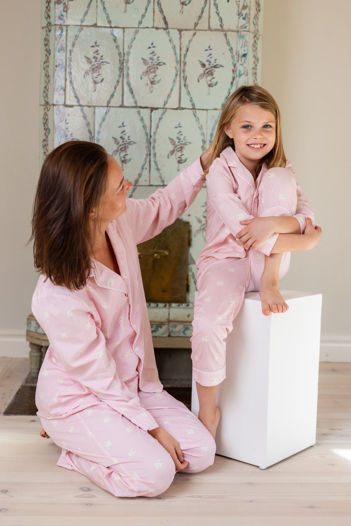 Adult and child wearing matching pink and white Pomeranian pajamas