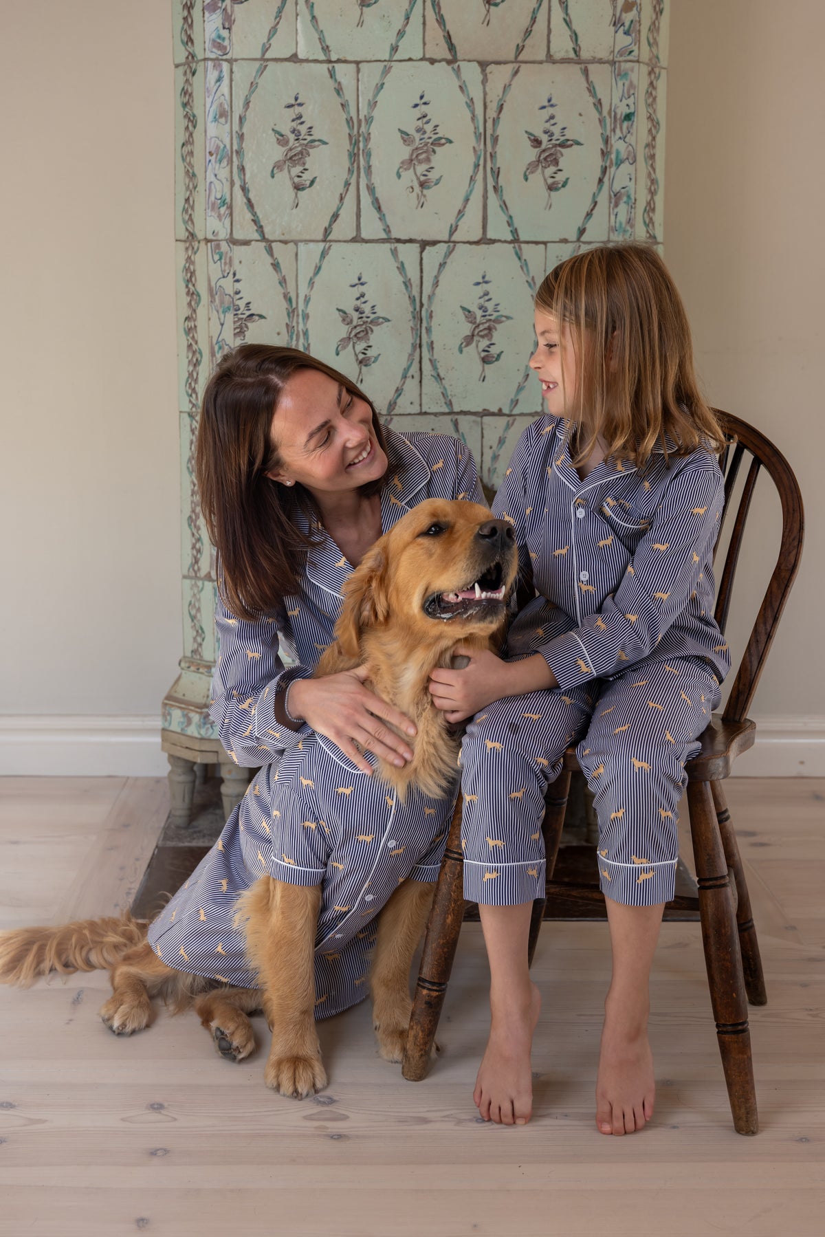 Adult, child and Golden Retriever in matching navy and white pajamas