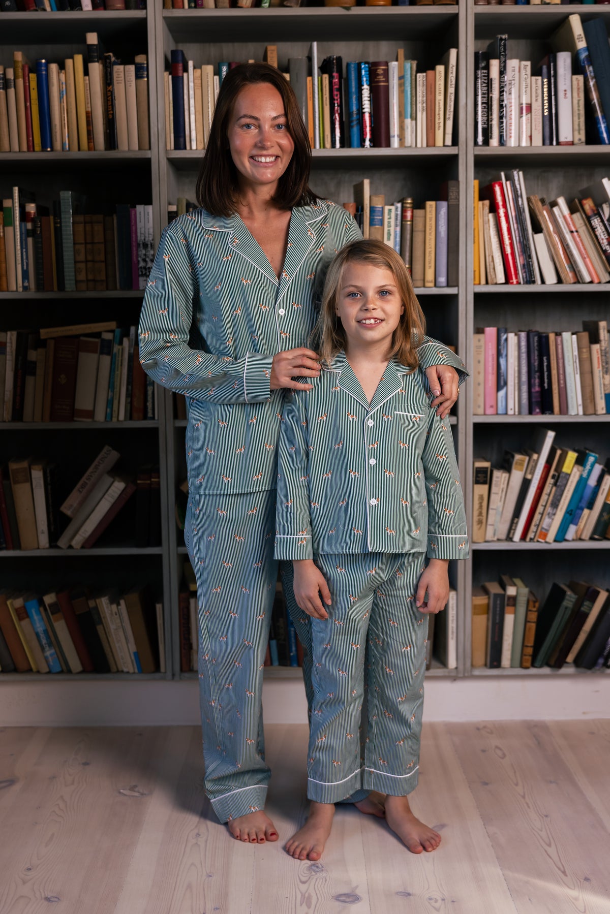 Adult and child wearing matching green and white Spaniel pajamas