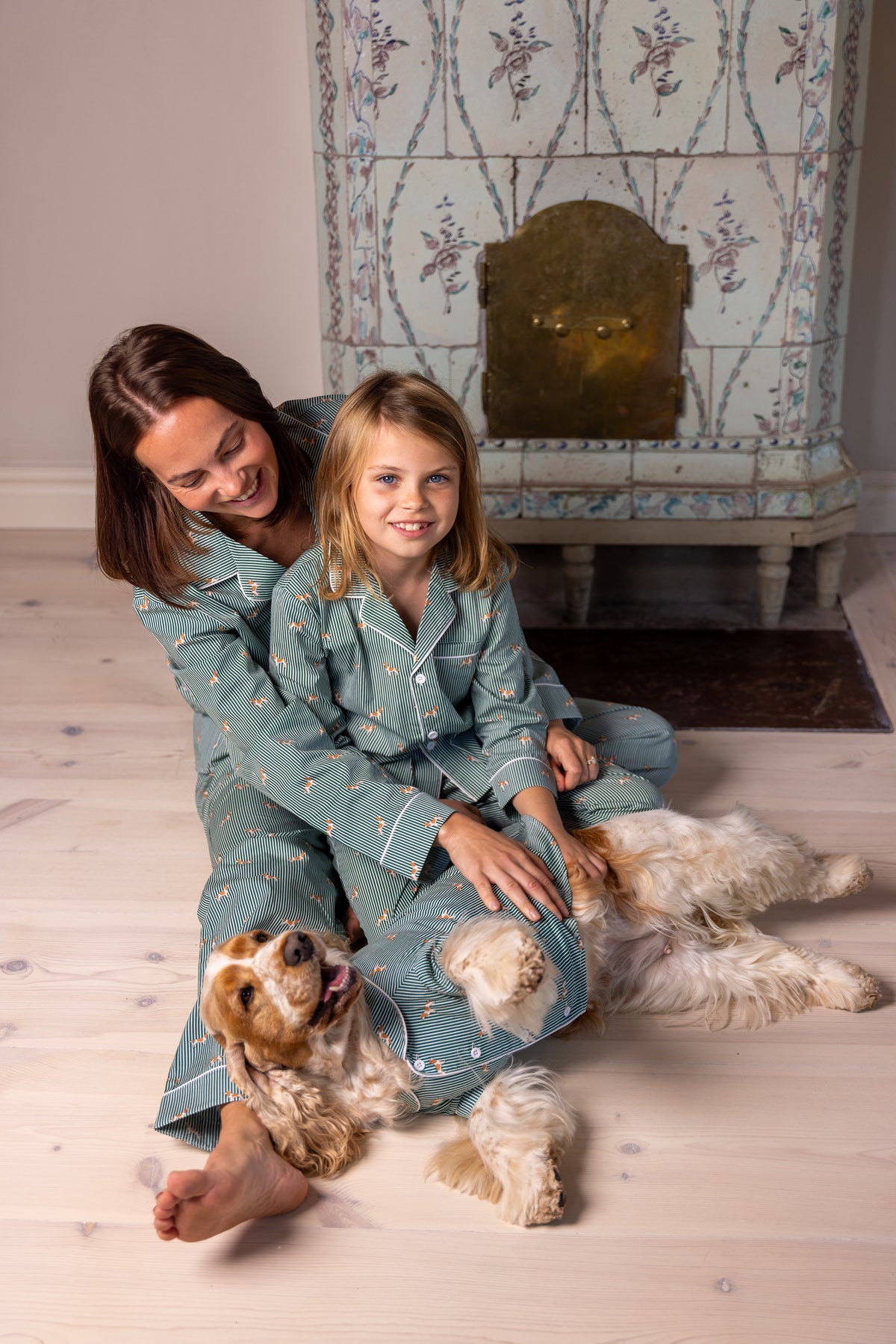 Adult, child and Spaniel relaxing in matching green and white pajamas