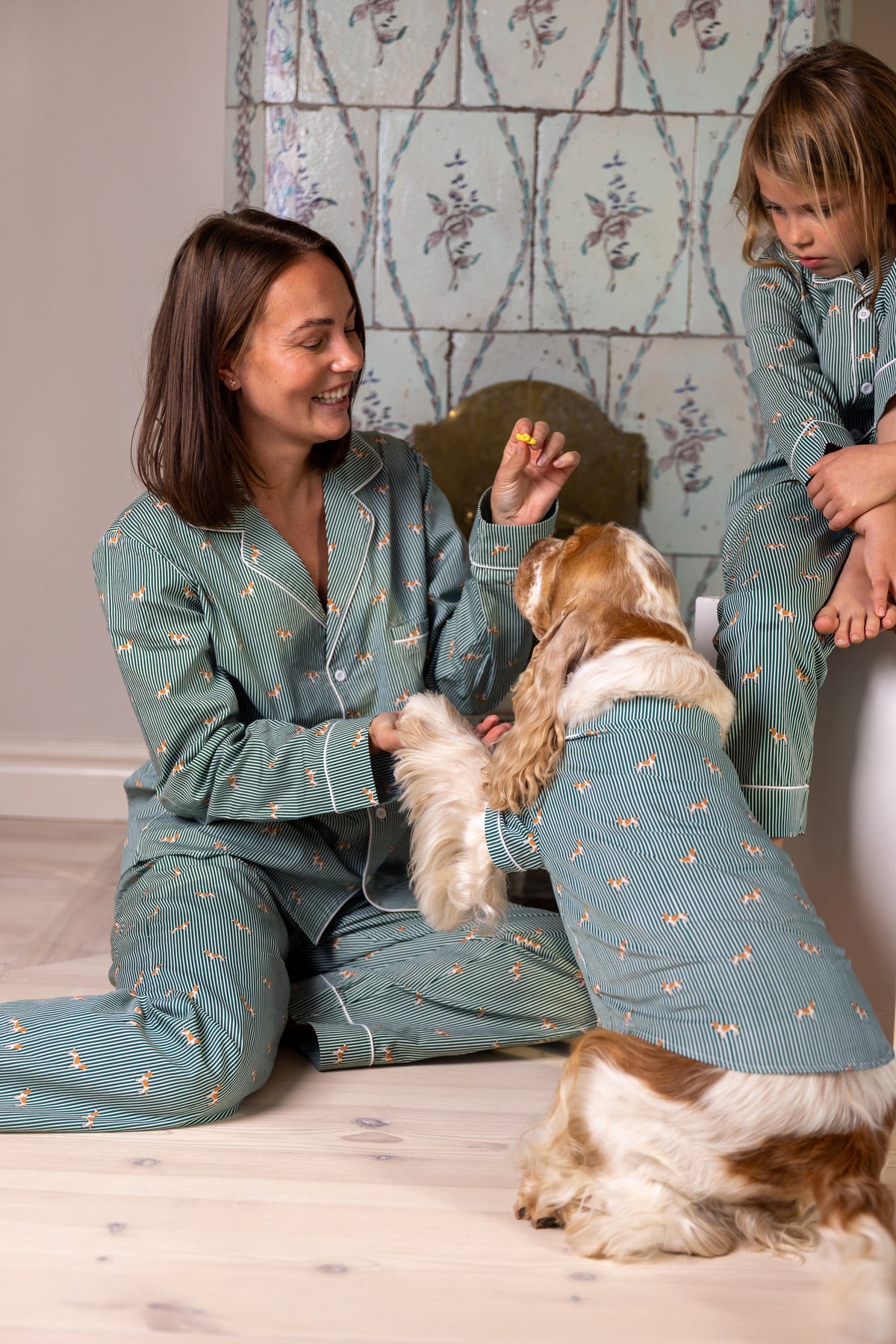 Adult, child and Spaniel wearing the green and white family pajama bundle