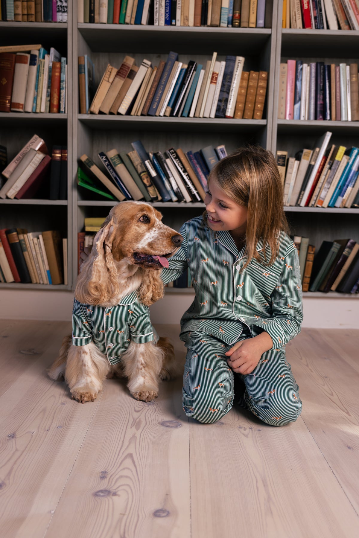 Child and Spaniel in matching green and white pajamas