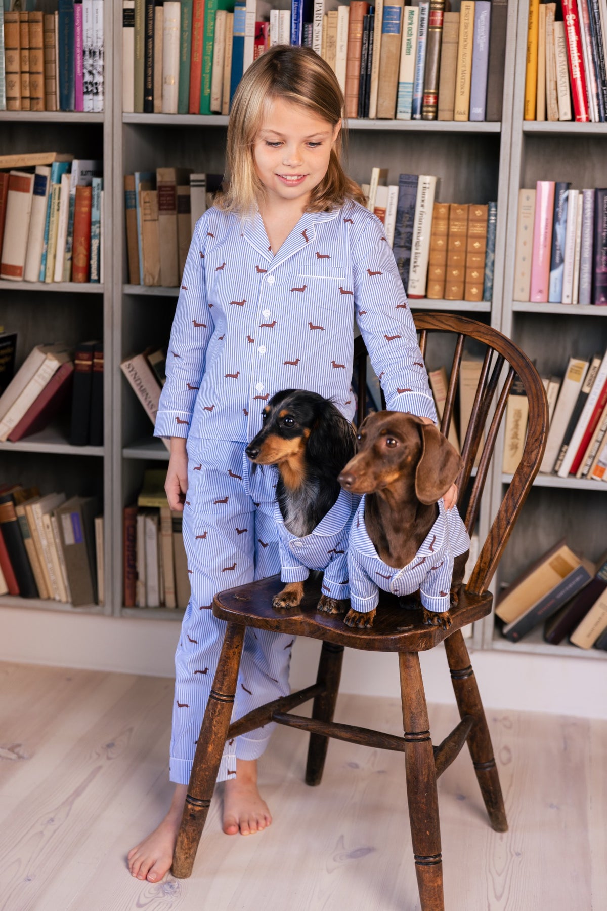 Child wearing the blue and white Dachshund kids pajama with two Dachshunds
