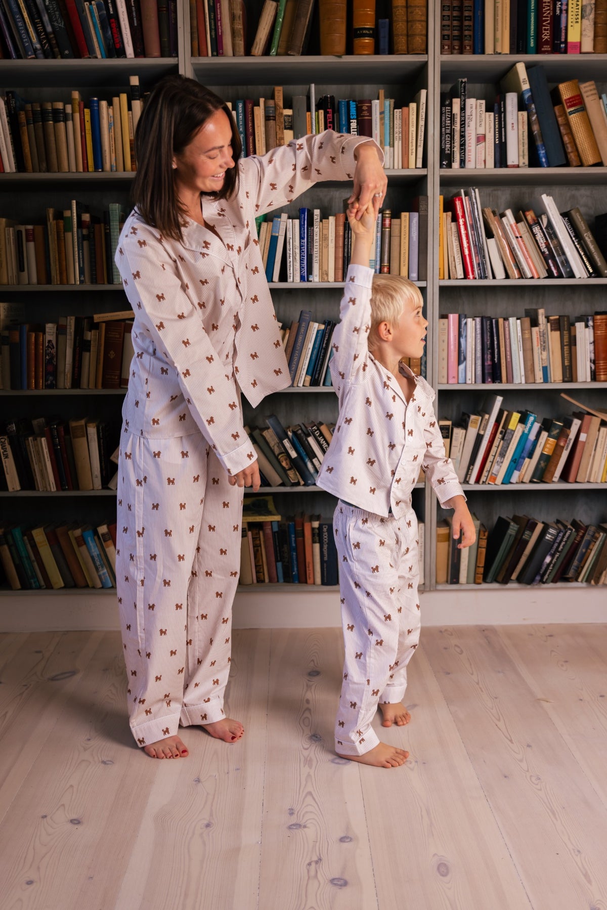Adult and child wearing matching brown and white Doodle pajamas