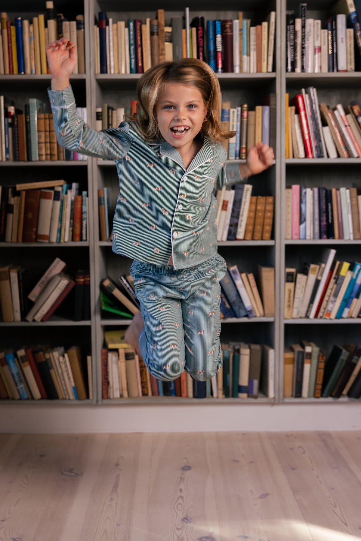 Child jumping in the complete green and white Spaniel kids pajama set