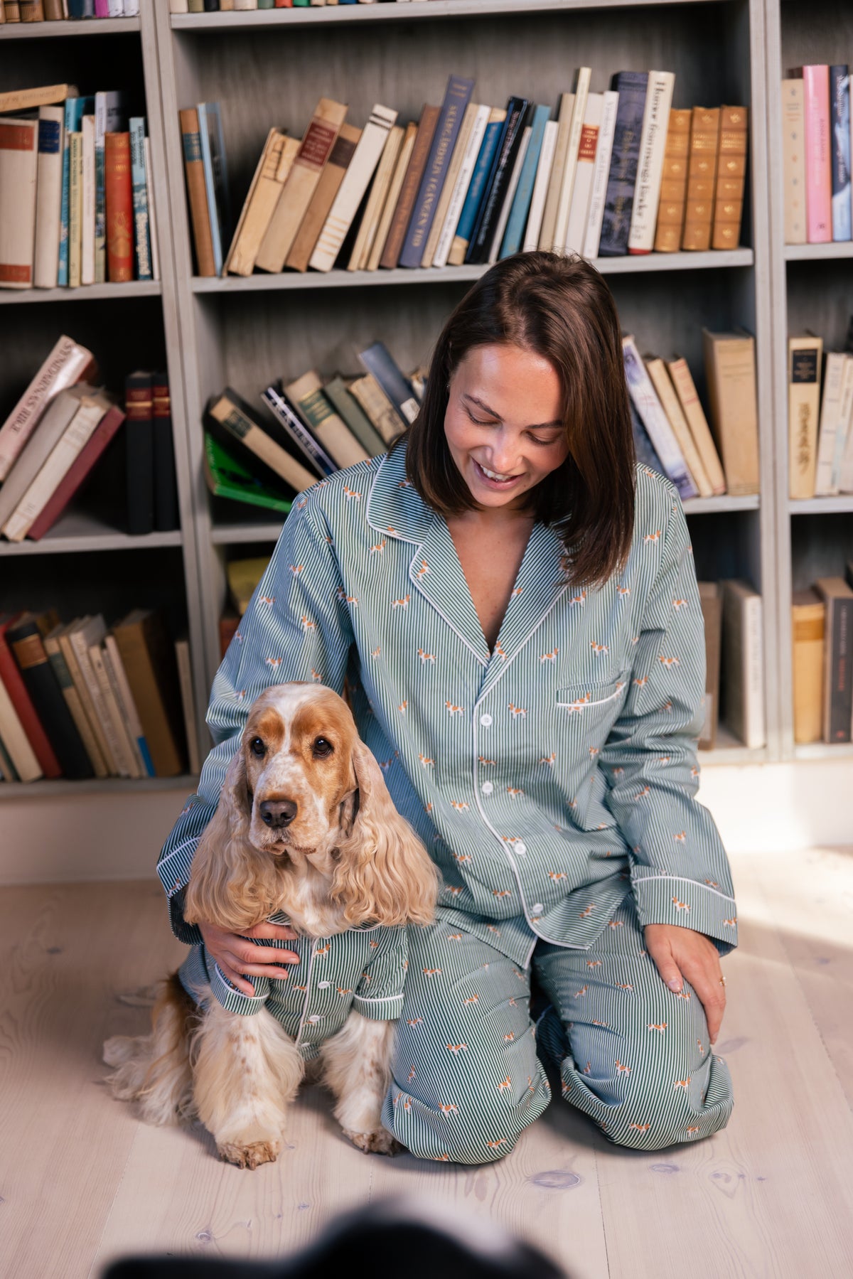 One adult and one Spaniel wearing their matching green and white pajamas