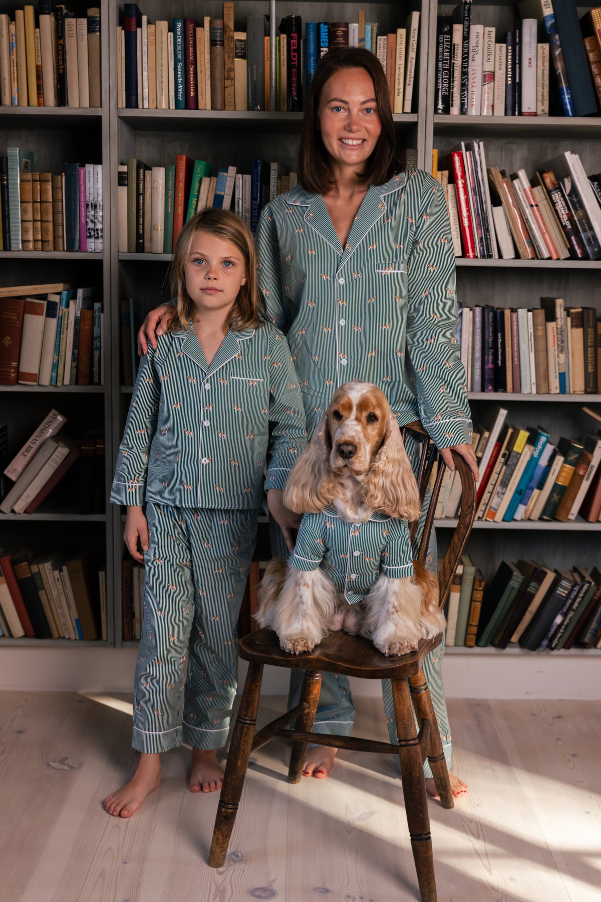 Adult wearing green and white Spaniel pajamas with a child and Spaniel